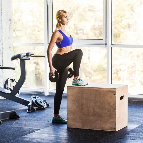 Woman doing step ups at a park bench